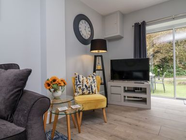 A living room with a television and a sofa at Beach Hideaway