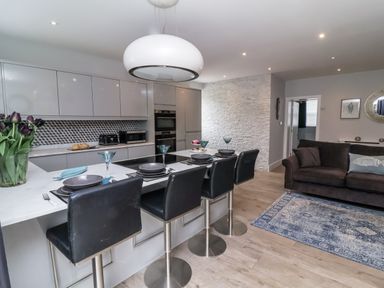 A kitchen with bar stools and a dining area at Beach Hideaway