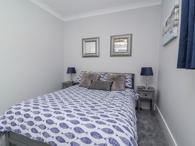 A bedroom with a bed and two bedside tables at Beach Hideaway