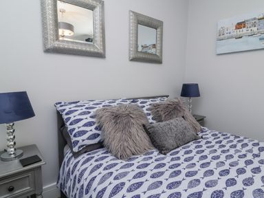 A bedroom with a bed and mirrors at Beach Hideaway