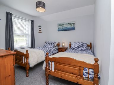 A bedroom with two single beds and a dresser at Beach Hideaway