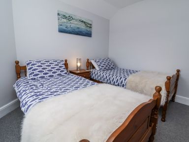 A bedroom with two single beds and a nightstand at Beach Hideaway