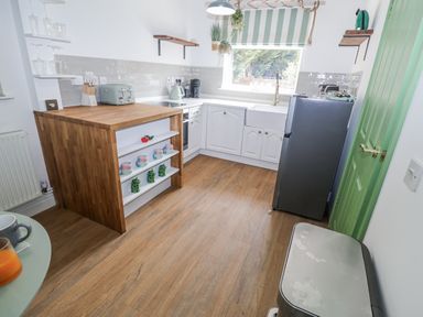 A kitchen with a table and stools at Annexe East End near Brantham