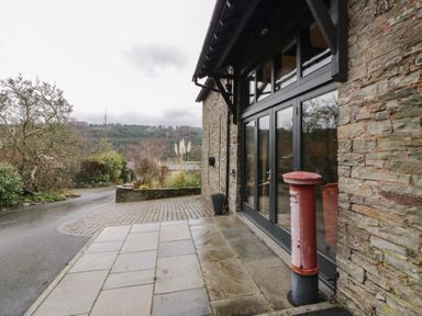 An outdoor view with a building entrance and a post box at The Barn at Sunny Barn Brecon