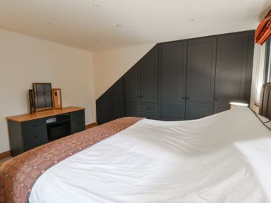 A bedroom with a bed and desk at The Barn at Sunny Barn in Brecon
