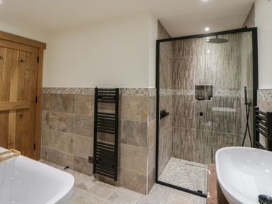 A bathroom with a shower and bathtub at The Barn at Sunny Barn Brecon