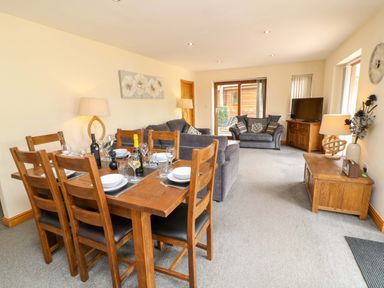 A dining room with a table and chairs at Sunnyside Lodge, Thorpe-On-The-Hill