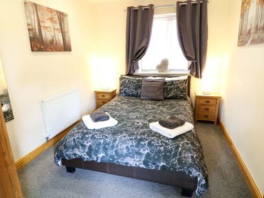 A bedroom with a bed and bedside tables at Sunnyside Lodge in Thorpe-On-The-Hill