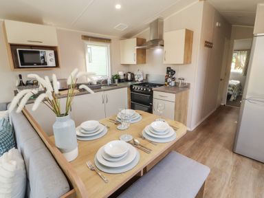 A kitchen with dining table set at Barnes Retreat in Carnforth