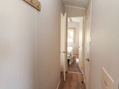 A hallway with doors to rooms and a window at Barnes Retreat in Carnforth