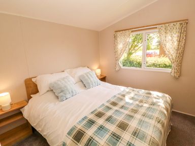 A bedroom with a bed and window at Barneys Retreat in Carnforth