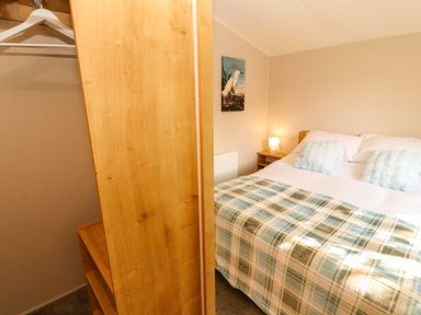 A bedroom with a bed and a wardrobe at Barneys Retreat in Carnforth