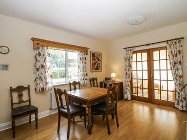 A dining room with a table and chairs at Knockroe Lodge