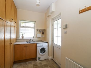 A laundry room with a washing machine and sink at Knockroe Lodge