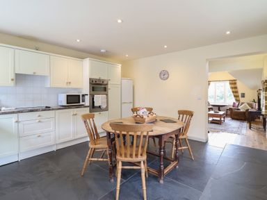 A kitchen with a dining table and chairs at Upper Pandy Farm in Welshpool
