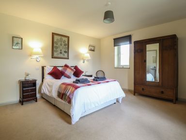 A bedroom with a bed and a wardrobe at Upper Pandy Farm in Welshpool