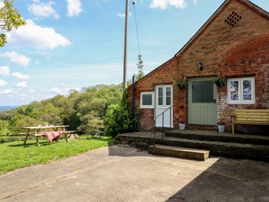 An outdoor area with a table and benches at Upper Pandy Farm in Berriew near Welshpool