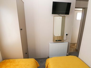A bedroom with a bed and wardrobe at No 13 Broadfield Farm Holiday Park, Saundersfoot