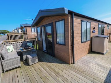 An outdoor patio area with seating and a table at No 13 Broadfield Farm Holiday Park in Saundersfoot