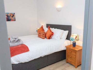 A bedroom with a bed and bedside table at Hedgehog Highway in Parkham