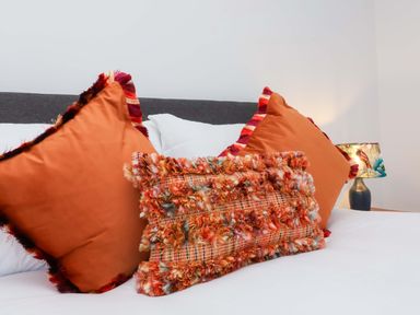 A bed with decorative pillows and a lamp at Hedgehog Highway, Parkham