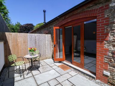 An outdoor patio with a table and chairs at Hedgehog Highway Parkham