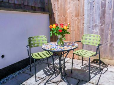 A table with chairs and flowers in a vase at Hedgehog Highway, Parkham