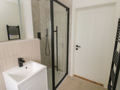 A bathroom featuring a sink, shower, and towel rail at Ty Landsker in Milford Haven
