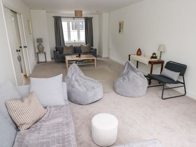 A living room with a coffee table and bean bags at Ty Landsker Houghton near Neyland
