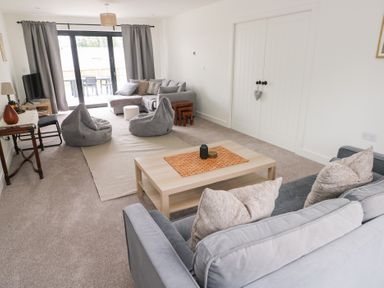 A living room with a sofa, bean bags, and a coffee table at Ty Landsker in Houghton near Neyland