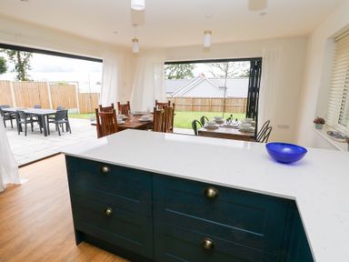 A kitchen with a dining table set for a meal at Ty Landsker in Houghton near Neyland
