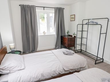 A bedroom with two beds and a window at Ty Landsker in Houghton near Neyland