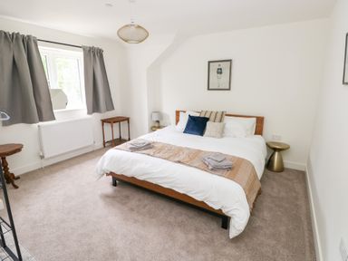 A bedroom with a bed and side tables at Ty Landsker in Houghton near Neyland