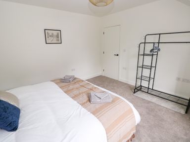 A bedroom with a bed and towel on the side at Ty Landsker in Houghton near Neyland