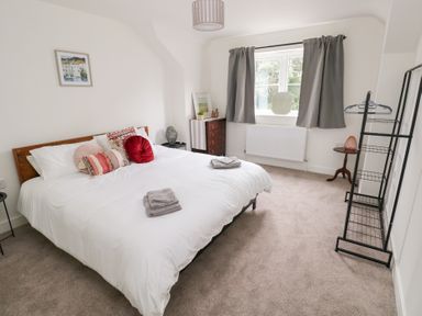 A bedroom with a bed and dresser at Ty Landsker Houghton near Neyland
