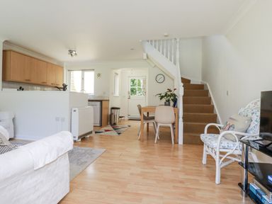 A living room with a sofa and dining area at Acorns in Falmouth