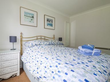 A bedroom with a bed and nightstand at Acorns, Falmouth