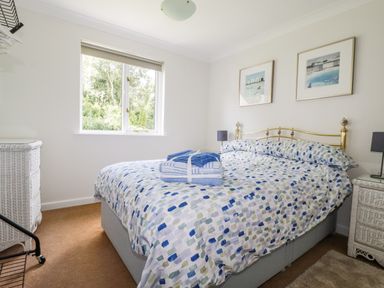 A bedroom with a bed and dresser at Acorns in Falmouth