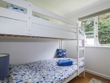 A bedroom with a bunk bed and a window at Acorns in Falmouth