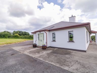 A house with a door and windows in an outdoor area at Ard Na Mara