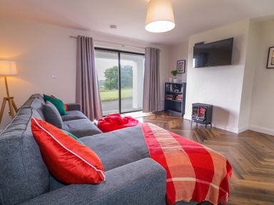 A living room with a sofa and television at Ard Na Mara