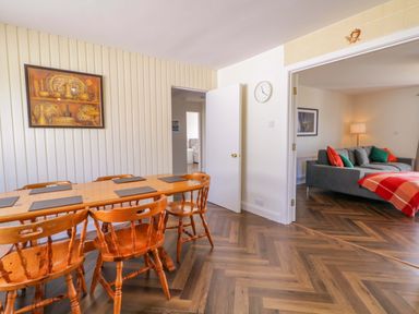 A dining room with a wooden table and chairs at Ard Na Mara