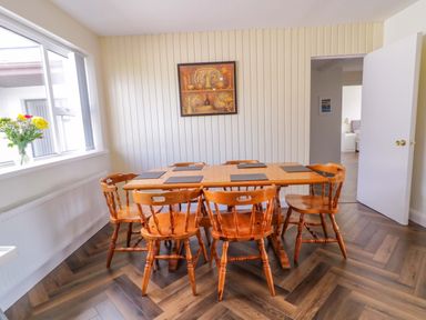 A dining table with wooden chairs in a dining room at Ard Na Mara