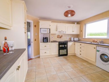 A kitchen with appliances and a window at Ard Na Mara