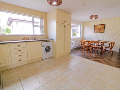 A kitchen with a dining area and a washing machine at Ard Na Mara