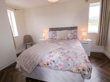A bedroom with a bed and bedside table at Ard Na Mara