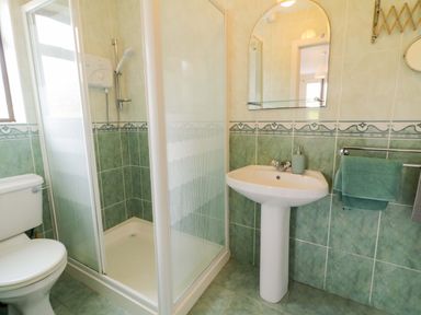 A bathroom with a shower, toilet, and sink at Ard Na Mara