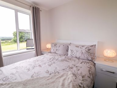 A bedroom with a bed and window at Ard Na Mara
