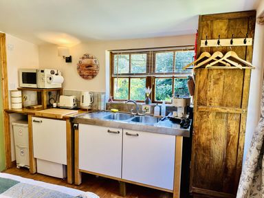 A kitchen with a sink and appliances at Harvey's Lodge in Lowertown, Helston