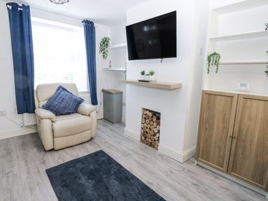 A living room with an armchair and television at Keekle Terrace in Cleator Moor